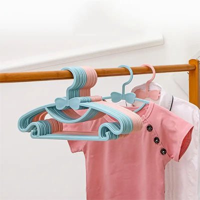 cintre enfant bleu avec t-shirt rose sur portant à vêtements