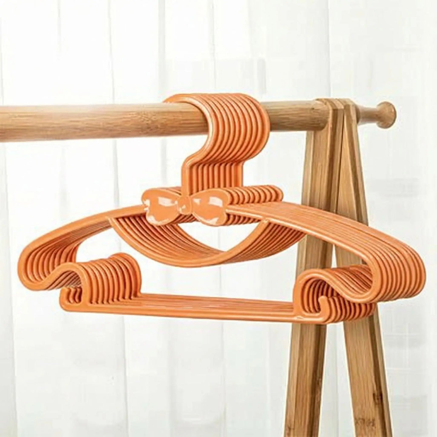 cintre enfant orange sur portant à vêtements