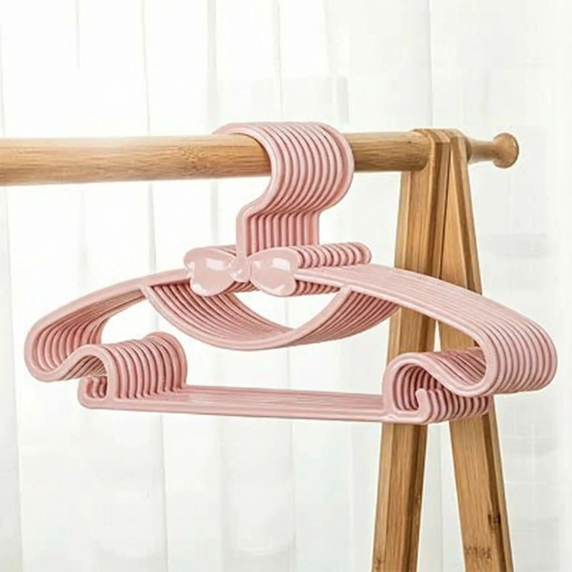 cintre enfant rose sur portant à vêtements