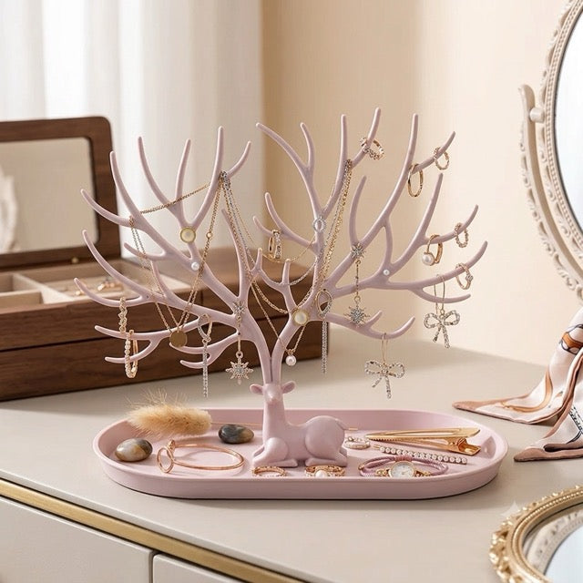 coffret à bijoux ouvert et arbre à bijoux rose sur commode avec miroir