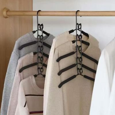 deux cintres avec différents pulls dans une penderie