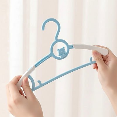 deux mains montrent le cintre enfant évolutif réglable bleu