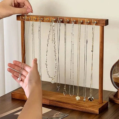 une main de femme prend un collier sur le portant à collier